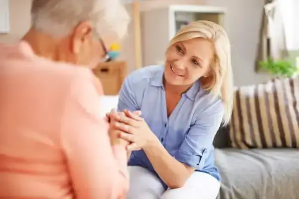 Woman holding elderly woman's hand
