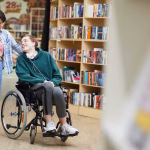 Cheerful,Positive,Handsome,Disabled,Student,With,Headphones,On,Neck,Sitting
